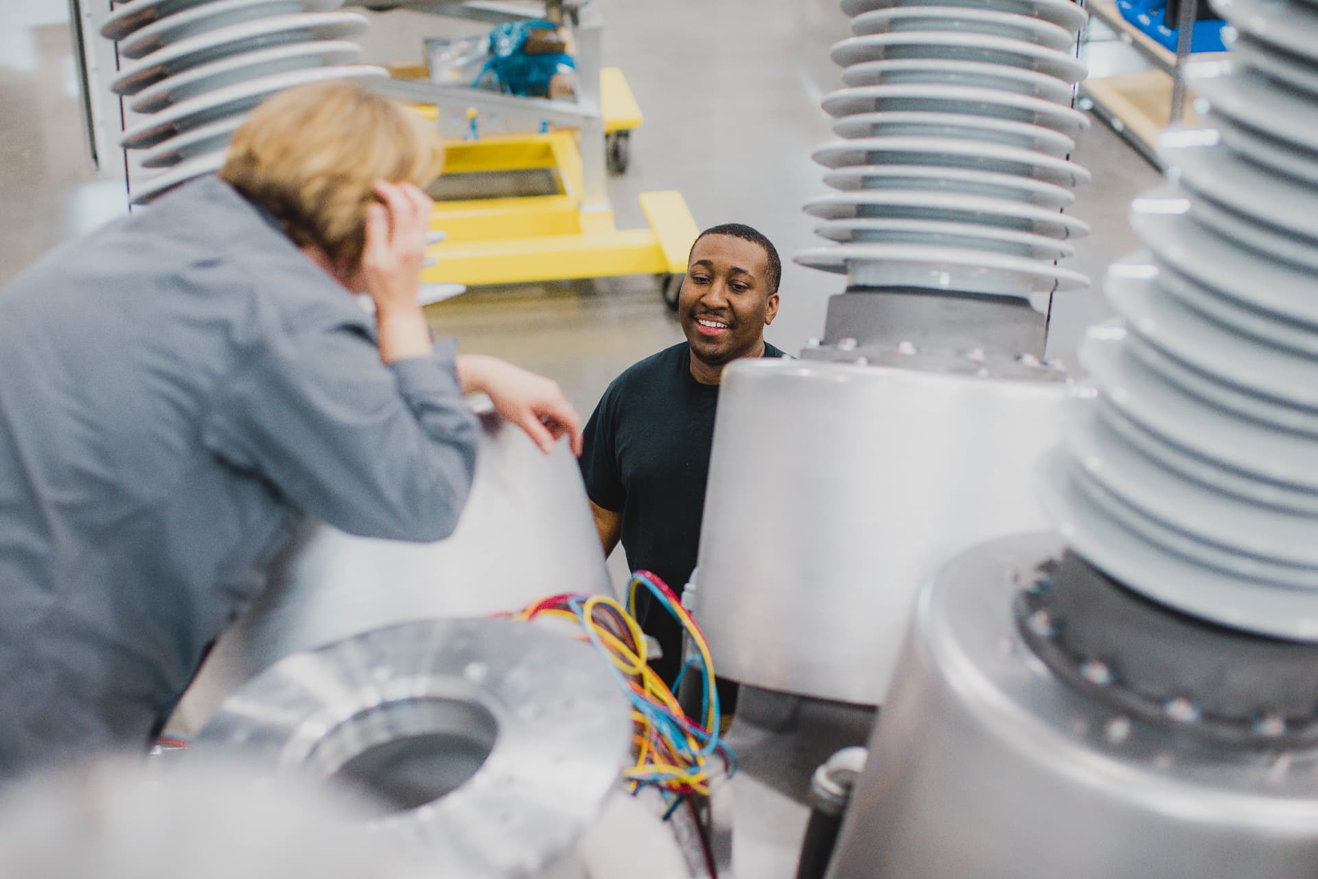 Two Meiden America Switchgear employees talking beside a breaker tank